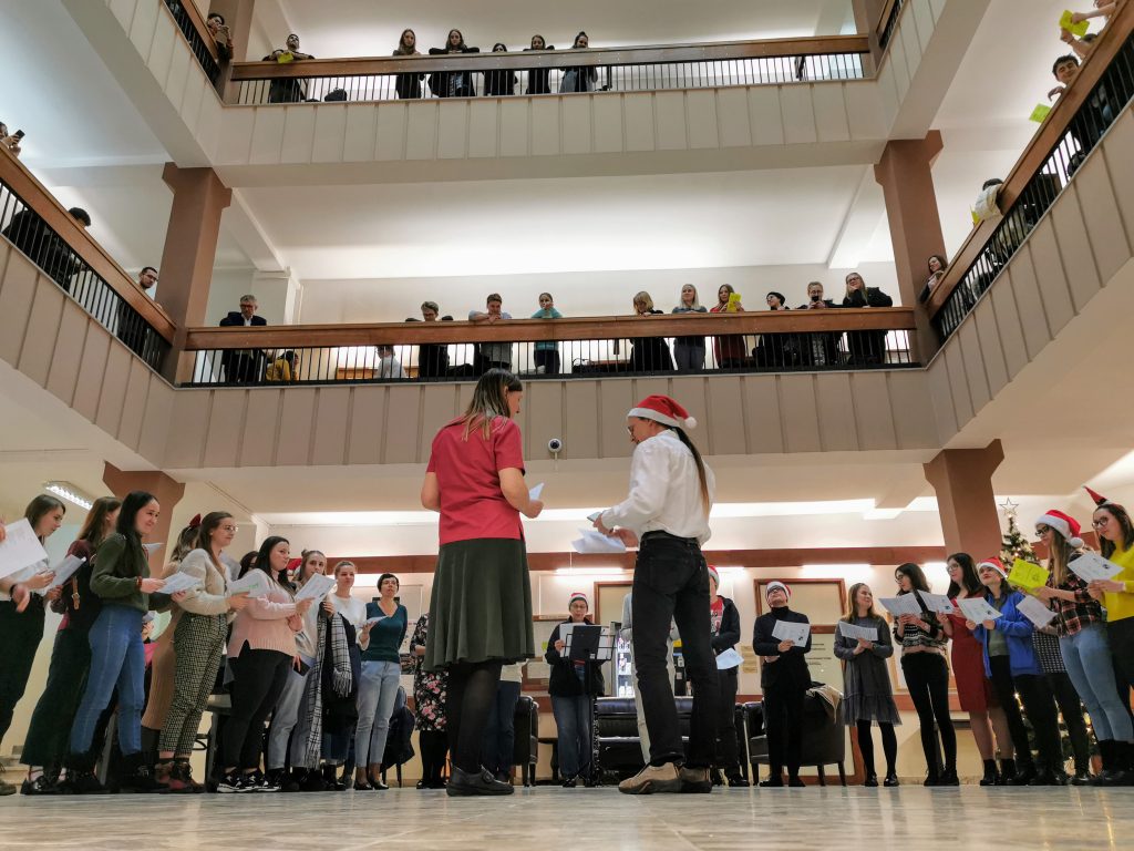 Śpiewanie kolęd w holu IFA, na pierwszym planie mgr Elaine Horyza i mgr Jason Schock